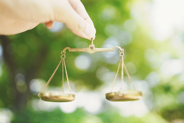 小さな天秤を持つ女性の手元