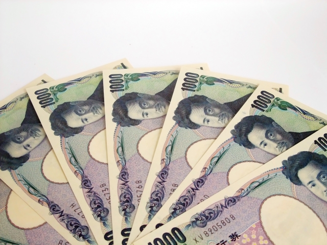 テーブルの上に扇状に並べられた複数枚の千円札