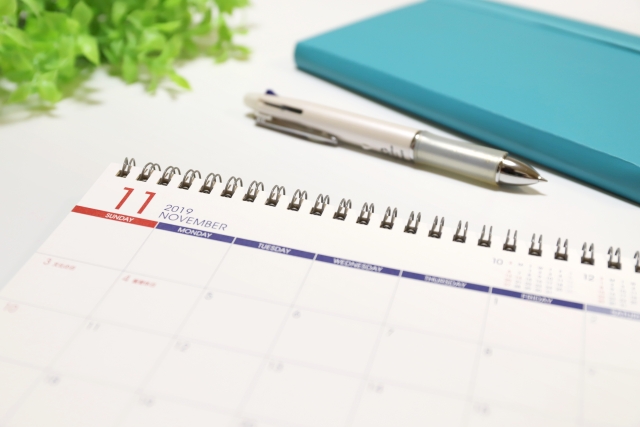 テーブルの上に並んでいる置き型カレンダーと手帳