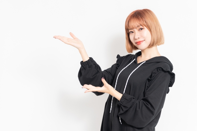 両方の手のひらを上に向けて案内のジェスチャーをする女性