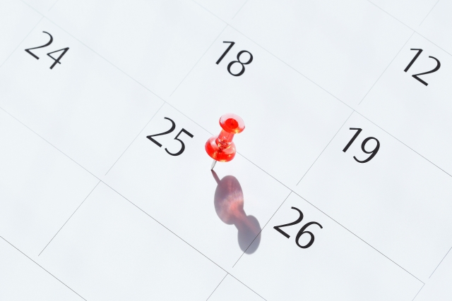 カレンダーの25日に刺さっているプッシュピン