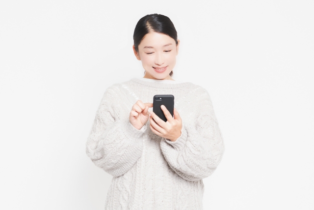 スマホを操作している笑顔の女性
