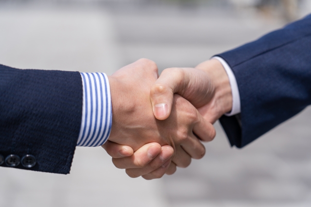握手をしている2人の男性の手元