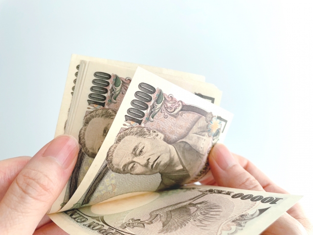 1万円札の束を数えている人の手元