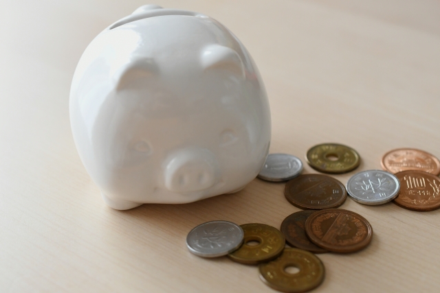小銭の横に置かれた豚の貯金箱