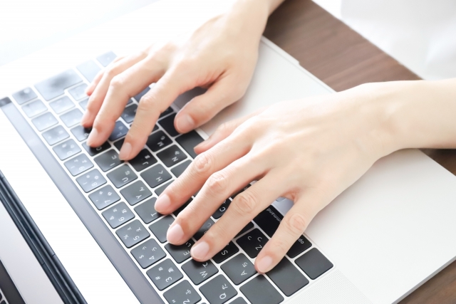 ノートパソコンを操作している女性の手元