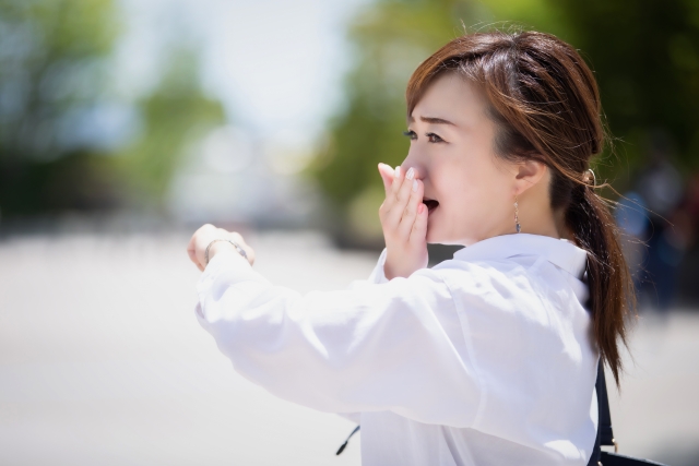 腕時計を見て慌てる女性