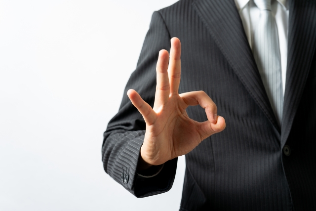 OKのハンドサインをしているスーツ姿の男性