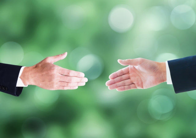 握手をしようとしている2人の男性の手元