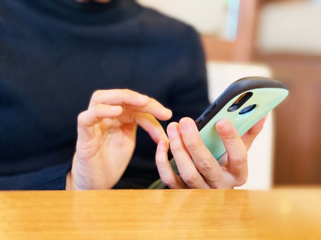 スマホを操作している女性の手元