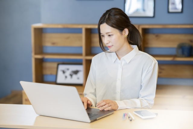 ノートパソコンを操作している笑顔の女性