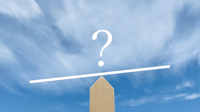 シーソーの上に浮かんでいるクエスチョンマークと青空