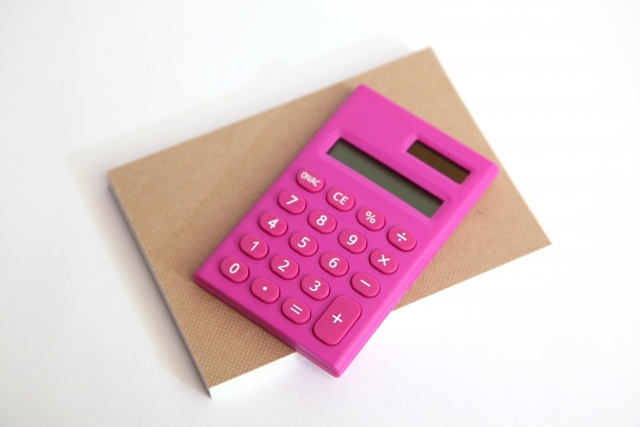 ノートの上に置かれたピンク色の電卓