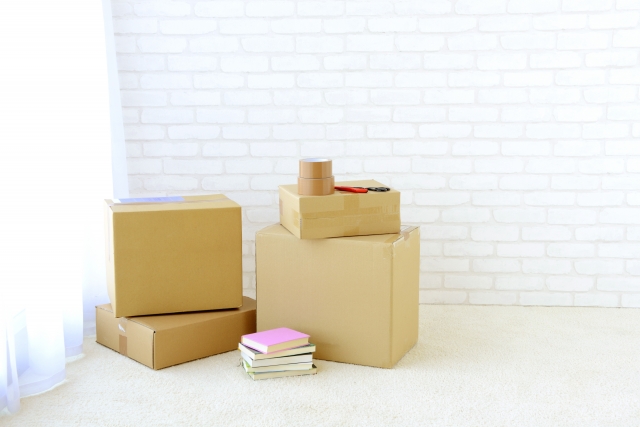 部屋の隅に置かれた段ボール箱とガムテープ