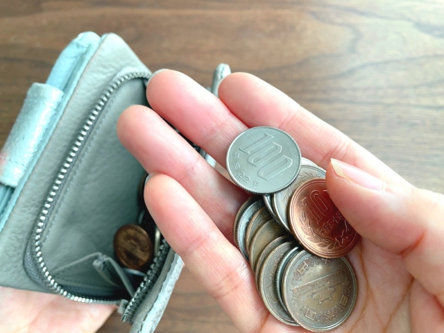 財布から出した小銭を数えている人の手元