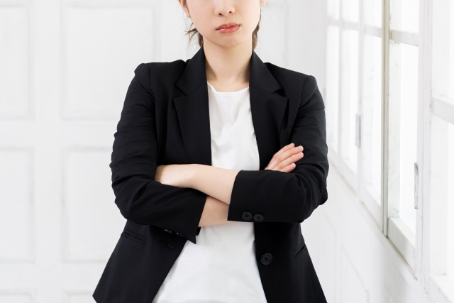 こちらを向いて腕組をしている女性