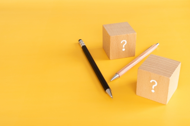 クエスチョンマークが印字された2つのブロックと2本の鉛筆