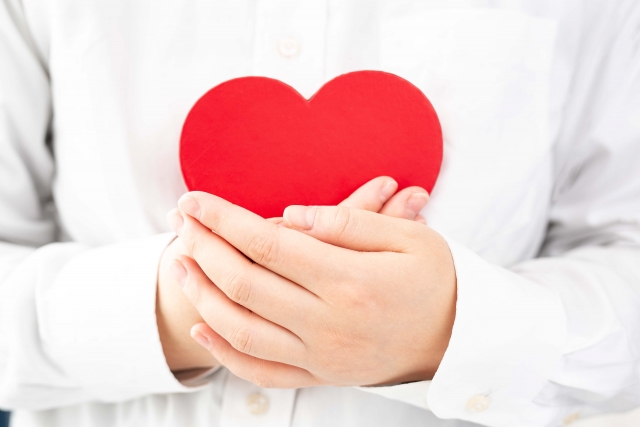 ハートのモチーフを両手で抱えている女性