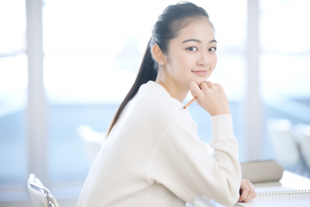 こちらを向いて微笑んでいる女子大学生