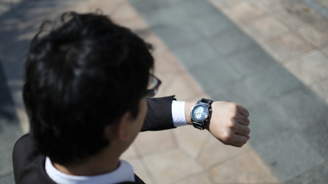 腕時計を見ているスーツ姿の男性