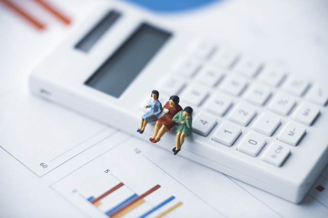 電卓に腰掛けている3体の女性のミニチュア