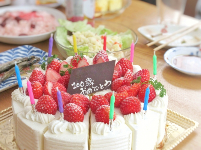 100歳おめでとうと書かれたチョコレートとバースデーケーキ