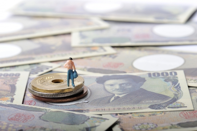 小銭の上に立っている男性のミニチュア