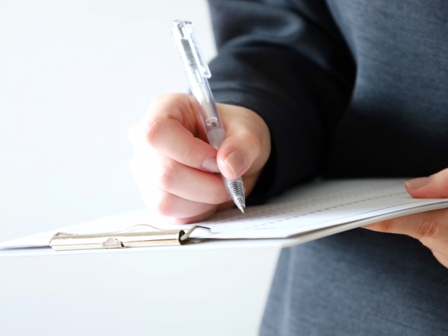 紙に書き込みをしている人の手元