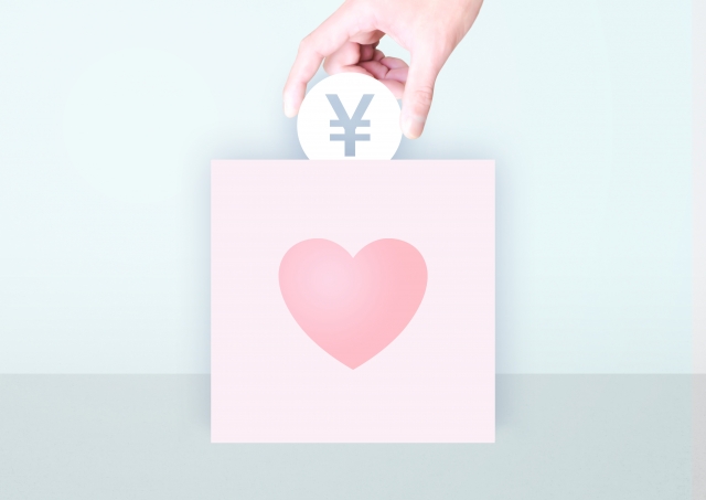 募金箱にお金を入れている手元