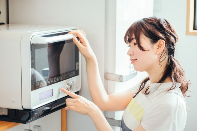 電子レンジを使う女性