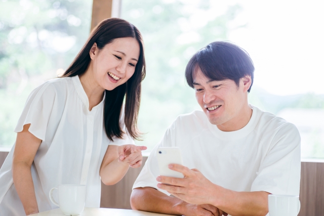 スマホ画面を楽しそうに見ている男女