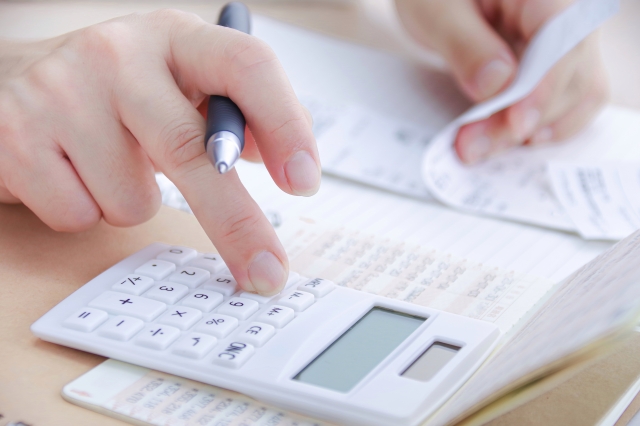 レシートを見ながら電卓を操作している女性の手元