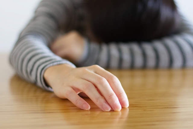 テーブルにうつ伏せ状態の女性