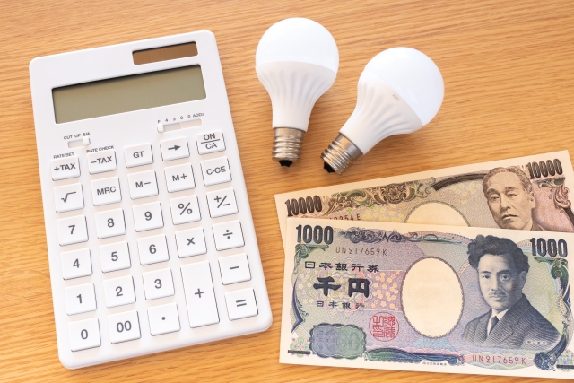 テーブルの上に並べらられた電卓とお札と電球