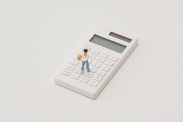 電卓の上でボールを持っている子どものミニチュア