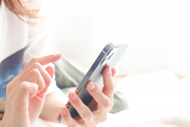 スマホを操作している女性の手元