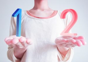 両手にそれぞれ1と2の数字を浮かべている女性