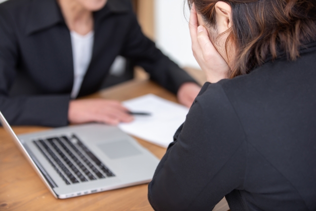 説明を受けて顔に手を当てている女性