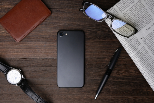 スマホを中心にして並べられた時計や名刺入れ