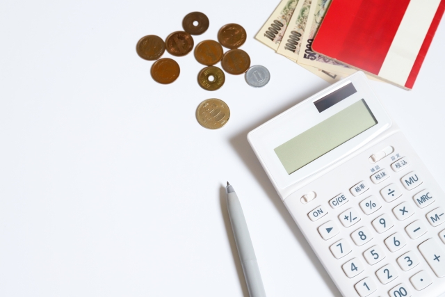 テーブルの上に置かれている電卓と小銭とお札