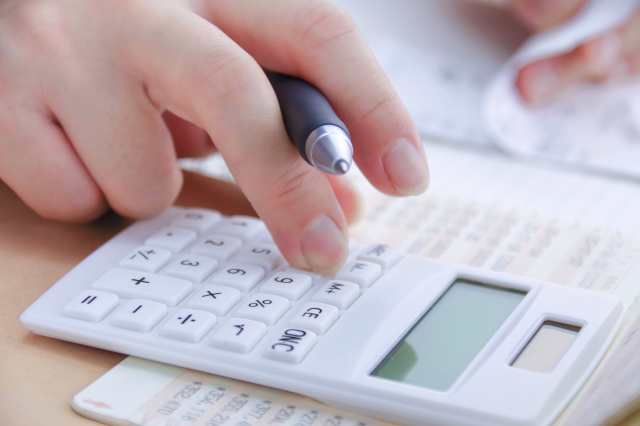 レシートを見ながら電卓を操作している女性の手元