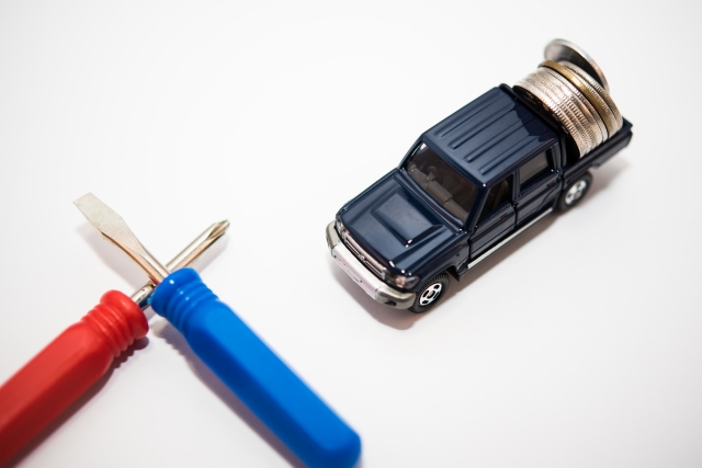 交差した2本のドライバーと車のミニチュア