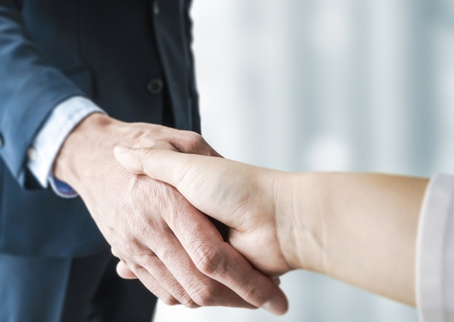 握手をしているビジネスマンの手元