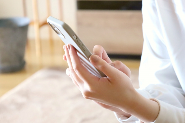 スマホを操作している女性の手元