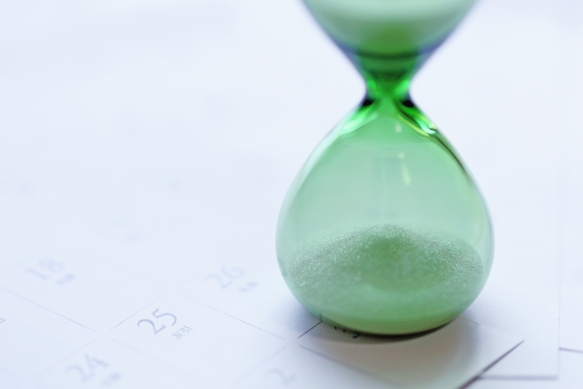 テーブルの上に置かれたカレンダーと砂時計