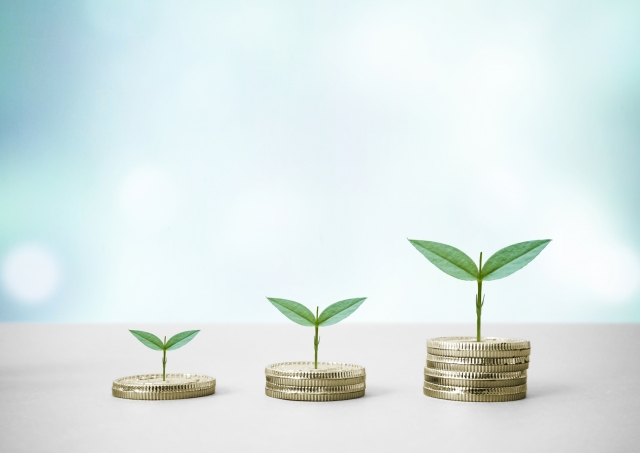 積み上げられたコインと発芽している植物の芽