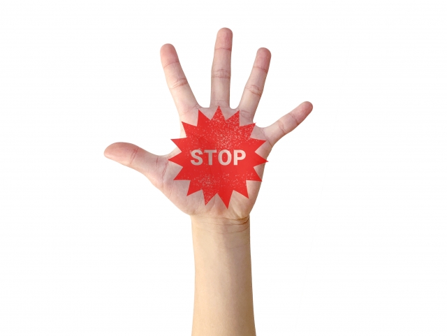 左手のひらに描かれたSTOPの文字