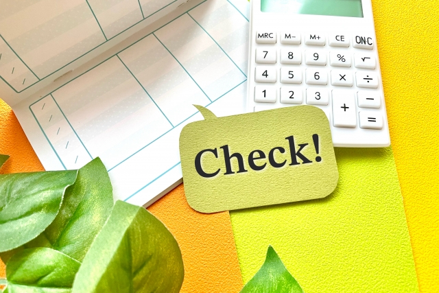 通帳と電卓とcheckの文字