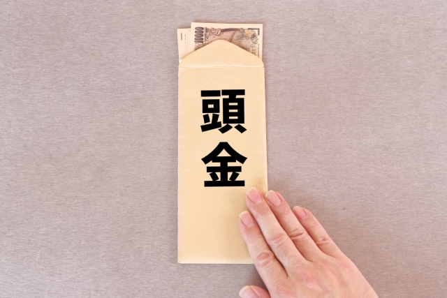 お金の入った封筒と添えられた女性の手