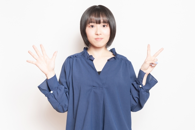 手で数字の7を示す女性